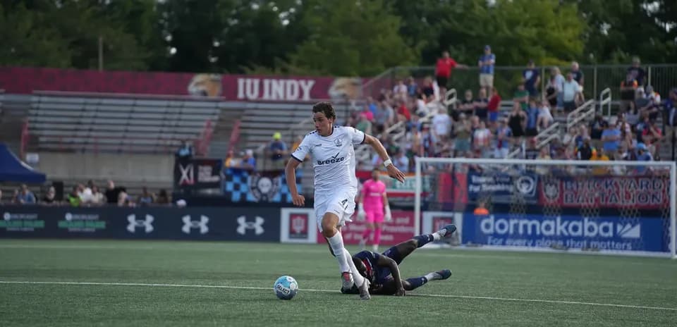 Player dribbling past opponent in football match
