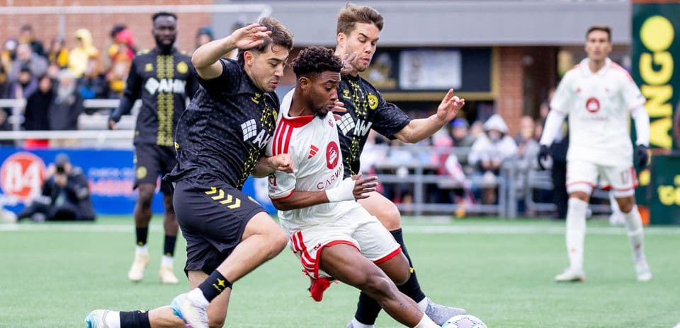 Pittsburgh Riverhounds player challenged by Miami FC defenders