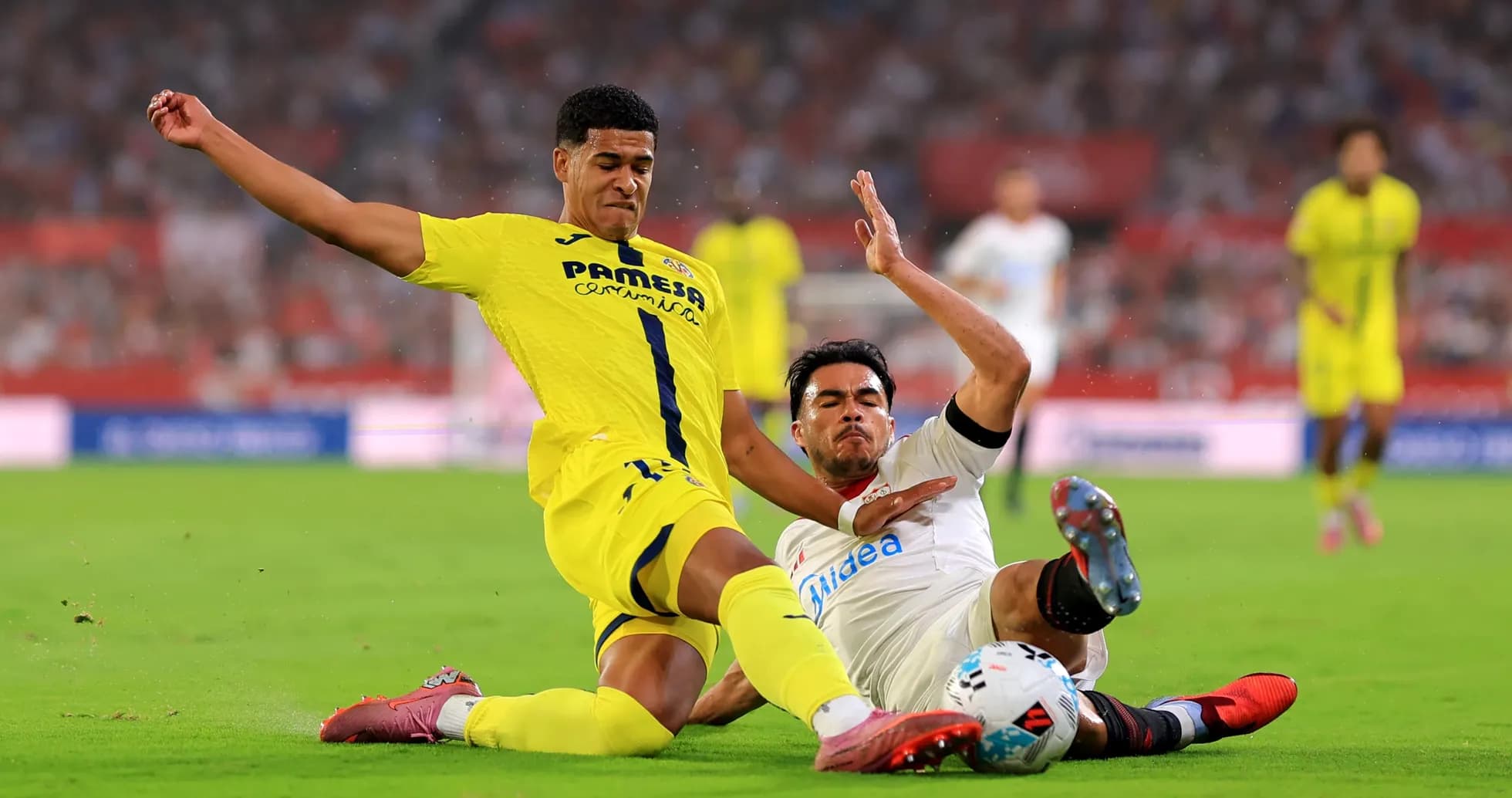 Villarreal player tackling Sevilla opponent on field
