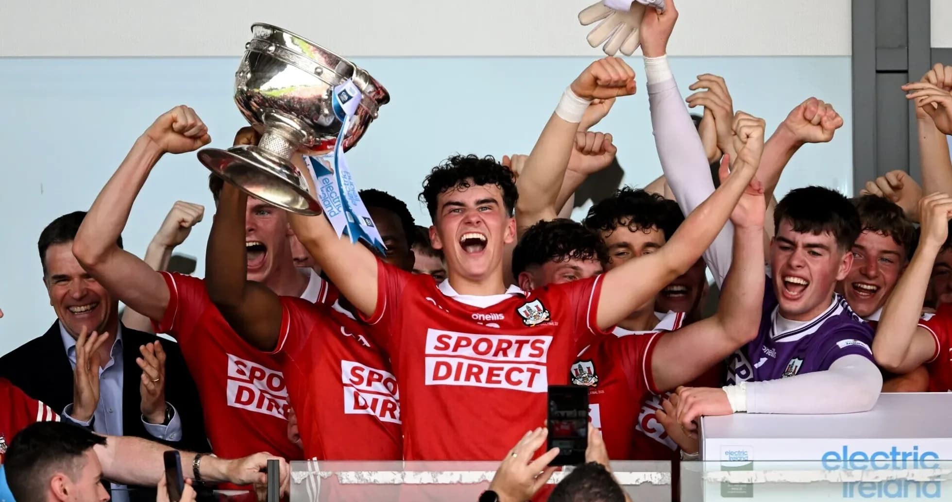 Team celebrating victory with trophy and cheers