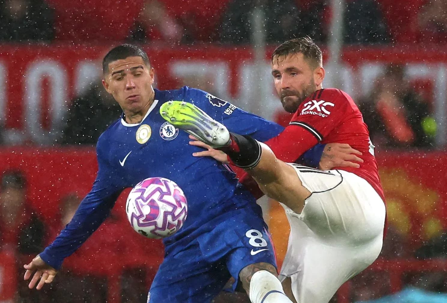 Chelsea player tackling Manchester United opponent