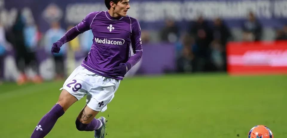 Player in purple jersey sprinting after the ball