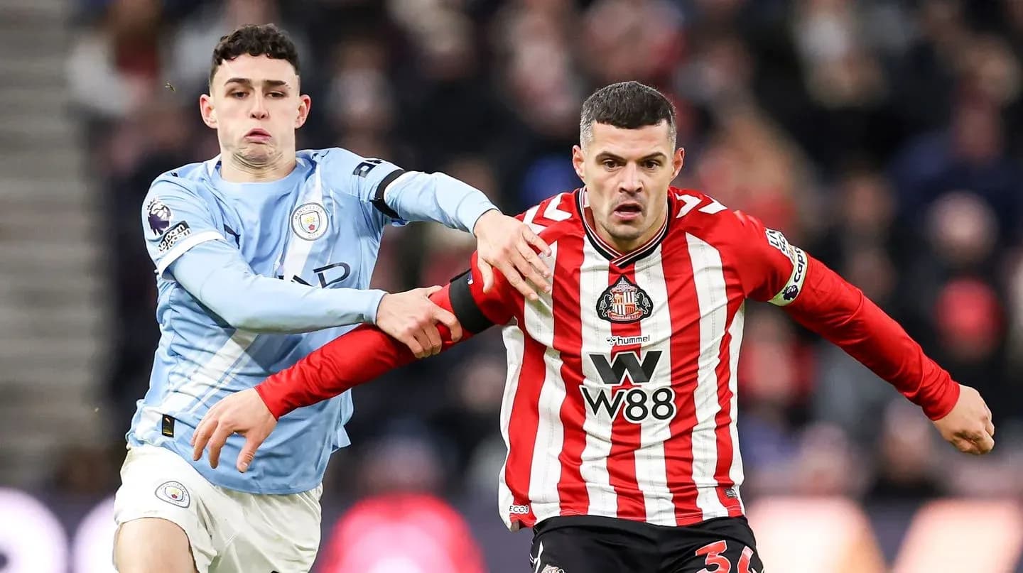 Manchester City player tackling Sunderland opponent