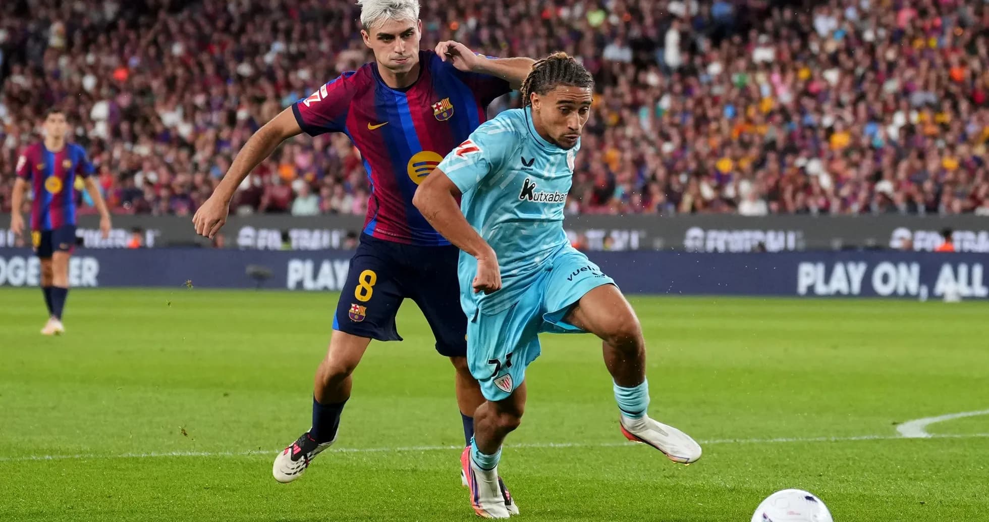 Barcelona player challenging opponent for the ball