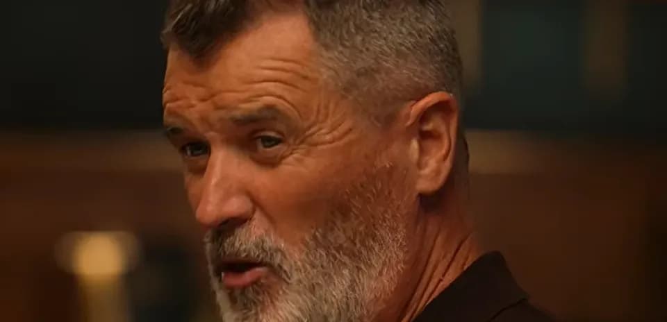 Man with gray beard speaking in a room