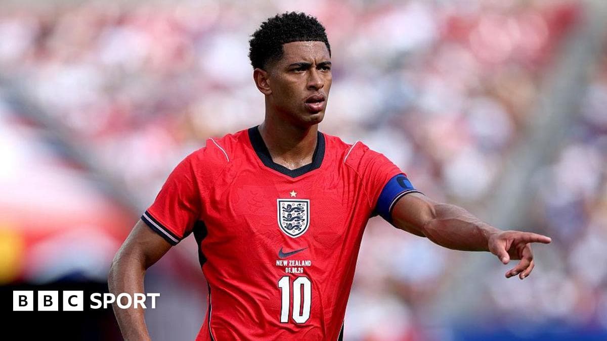 Player in red England jersey directing teammates on field