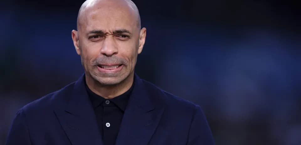 Man in a dark suit speaking at an event