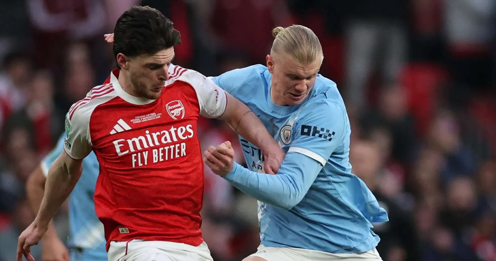 Arsenal player tackling Manchester City player