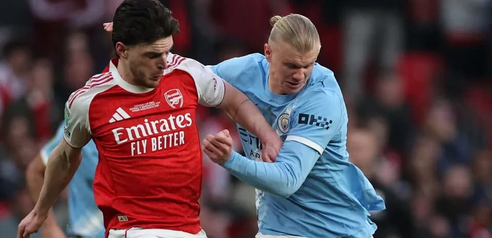 Arsenal player tackling Manchester City player