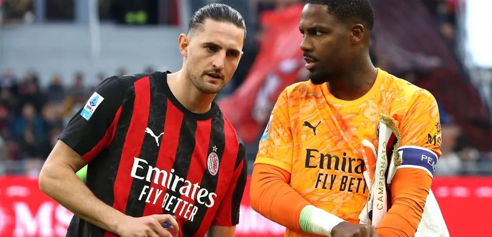Two AC Milan players discussing on the field