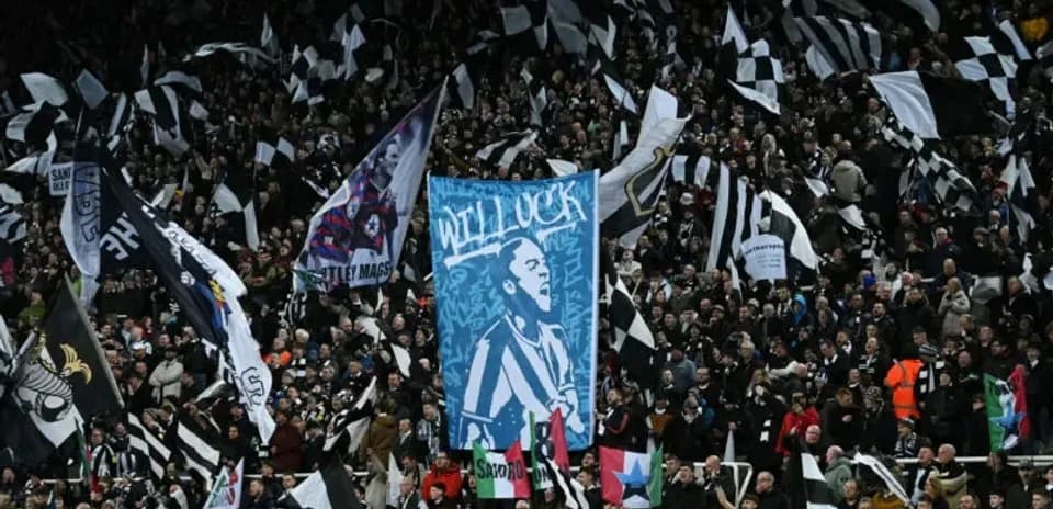 Crowd waving black and white flags at stadium