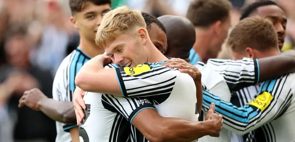 Players celebrating a goal with embraces on field