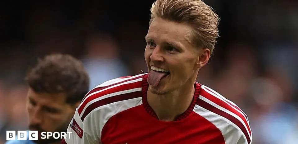 Player celebrating with tongue out in Arsenal jersey