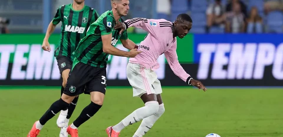 Sassuolo player tackling Juventus opponent during match