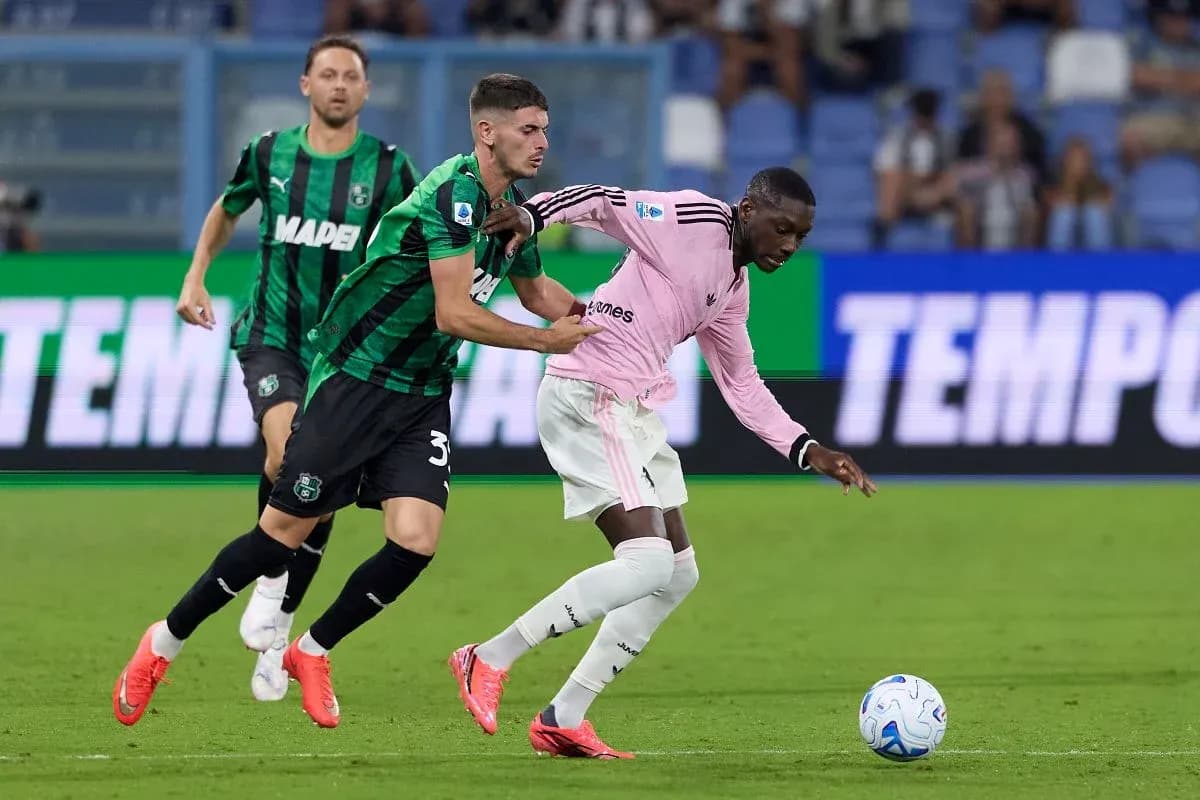 Sassuolo player tackling Juventus opponent during match