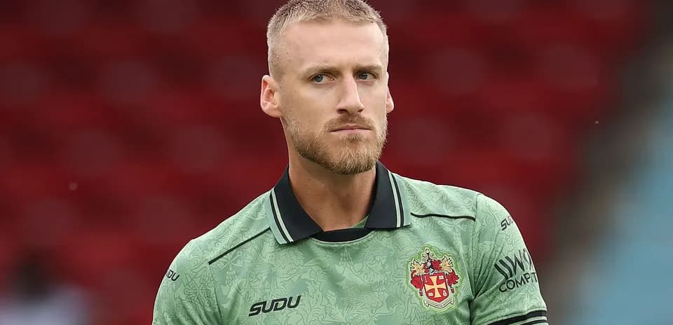 Goalkeeper in green kit during match warm-up