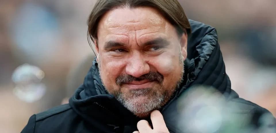 Coach smiling while adjusting his jacket collar