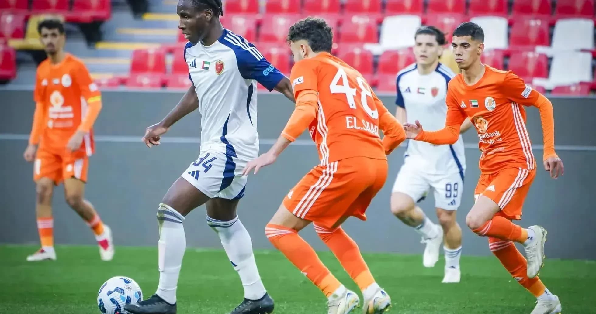 Khorfakkan U23 player dribbling past Al Sharjah U23
