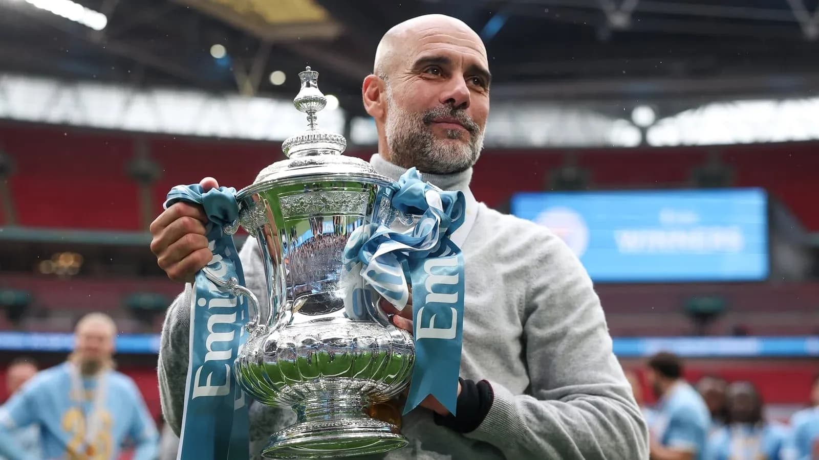 Coach holding trophy at Wembley Stadium celebration
