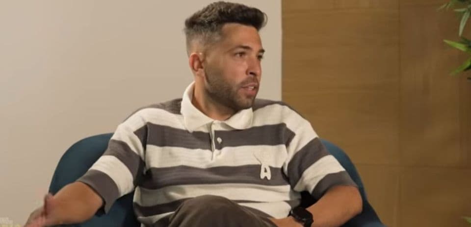 Man in striped shirt speaking during interview