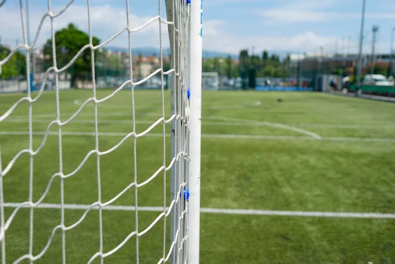 Goal net in foreground with soccer field background