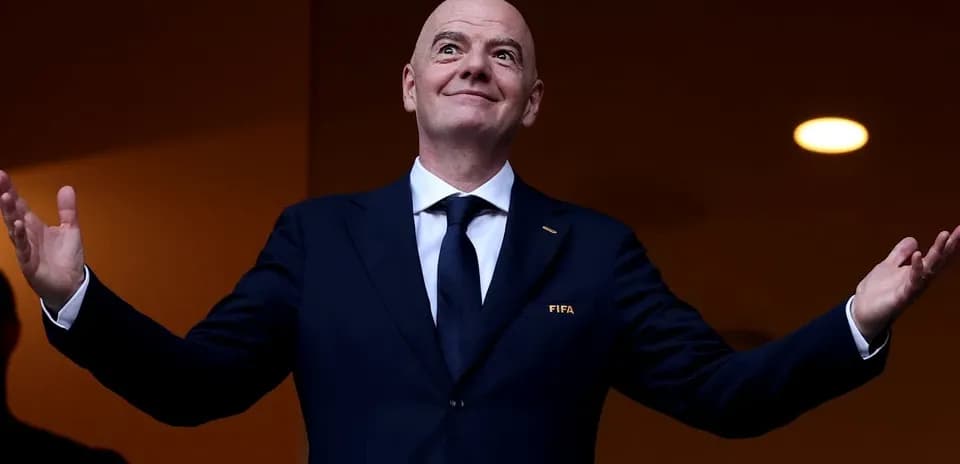 FIFA president gesturing from a VIP box