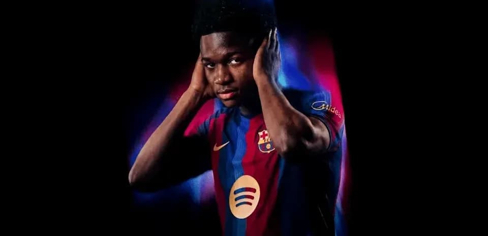 Player posing in Barcelona jersey with dramatic lighting
