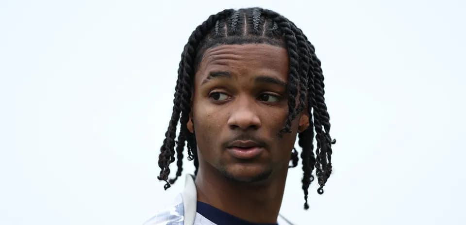 Player with braided hair looking away outdoors