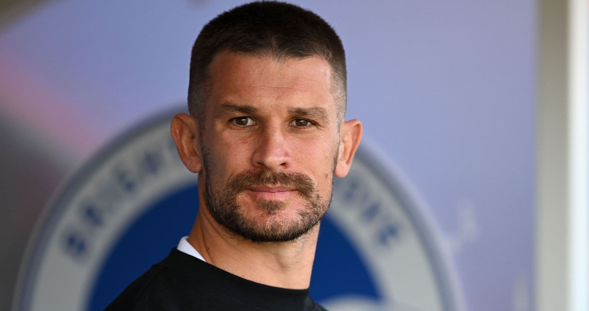 Player with short hair and beard posing for camera