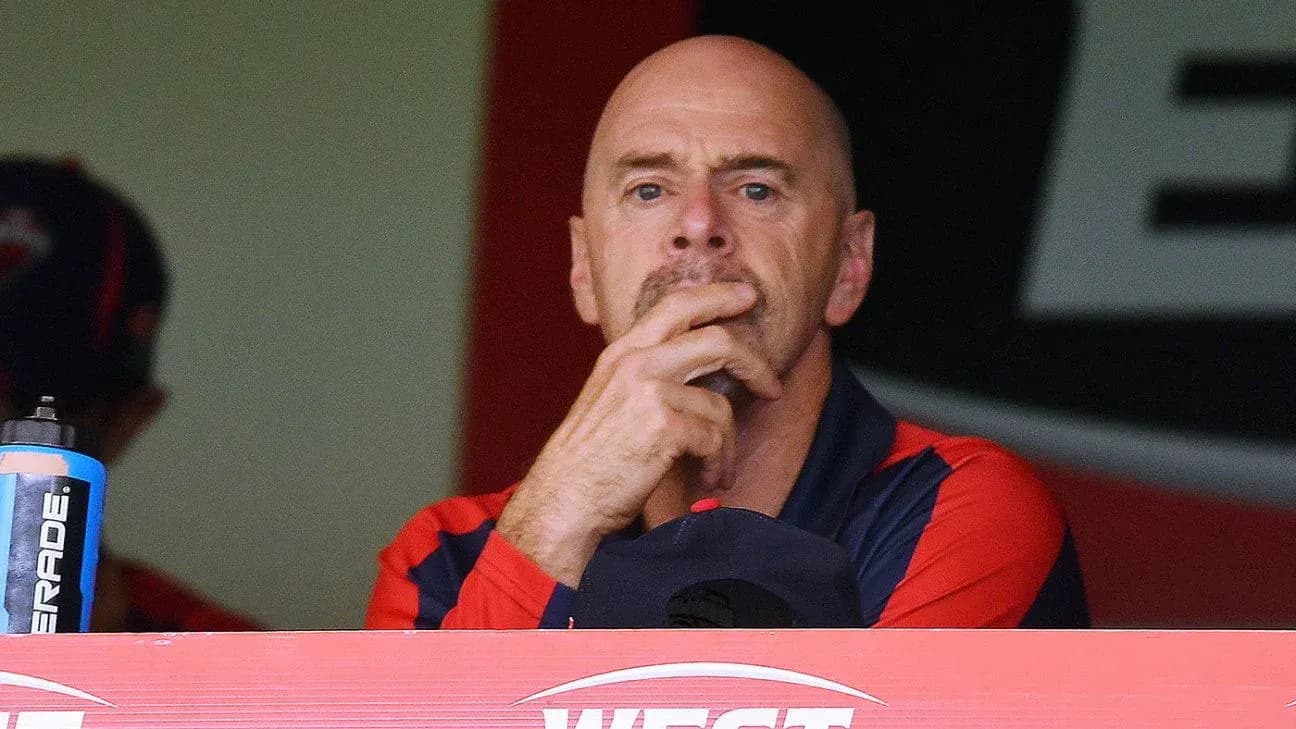 Coach observing the game from the dugout