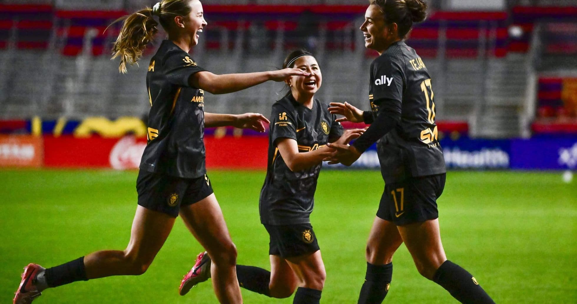 Three players celebrating a goal during match