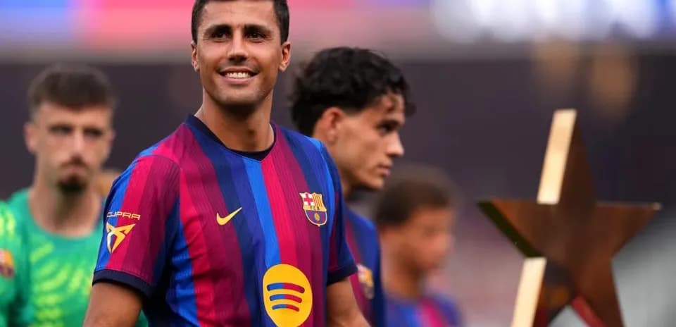 Player smiling while holding trophy during ceremony