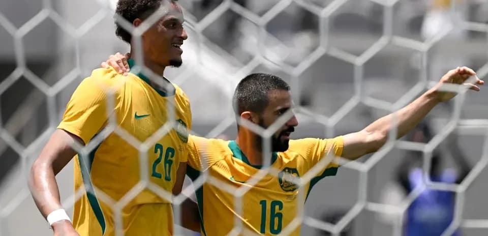 Two Australian players celebrating a goal together