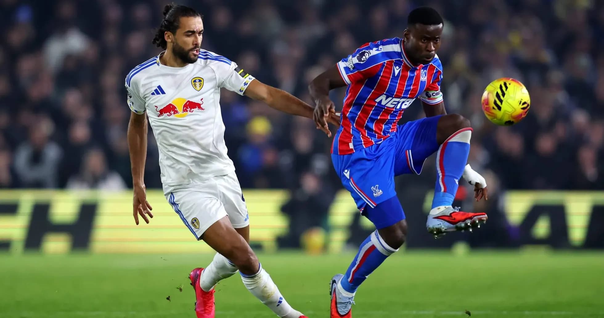 Crystal Palace player challenging Leeds player for ball