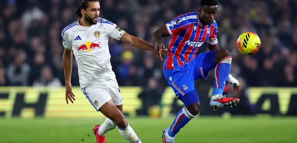 Crystal Palace player challenging Leeds player for ball