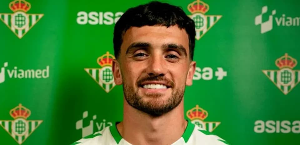 Player posing in front of Real Betis backdrop