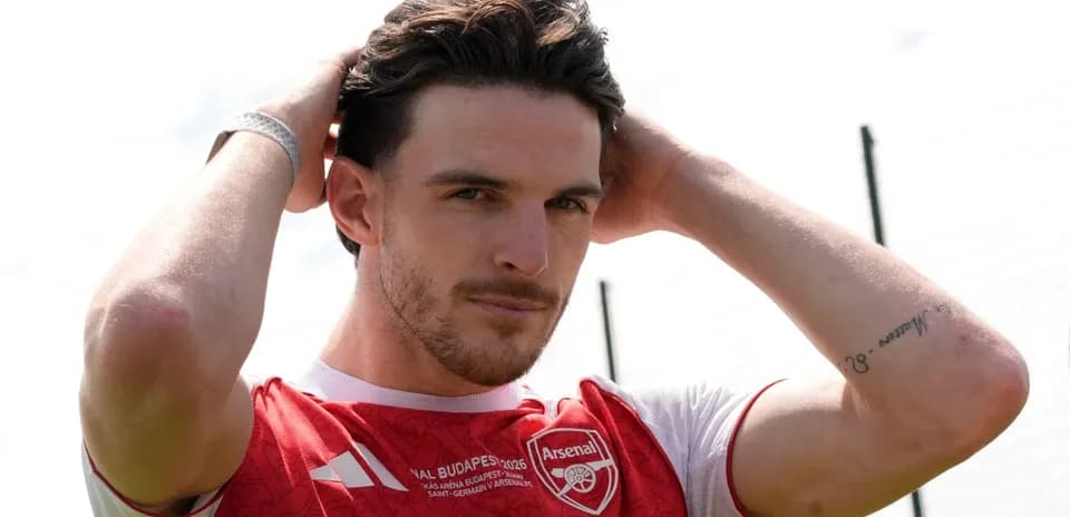 Player adjusting hair while wearing Arsenal jersey