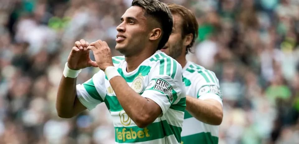Player celebrating goal with heart gesture on field