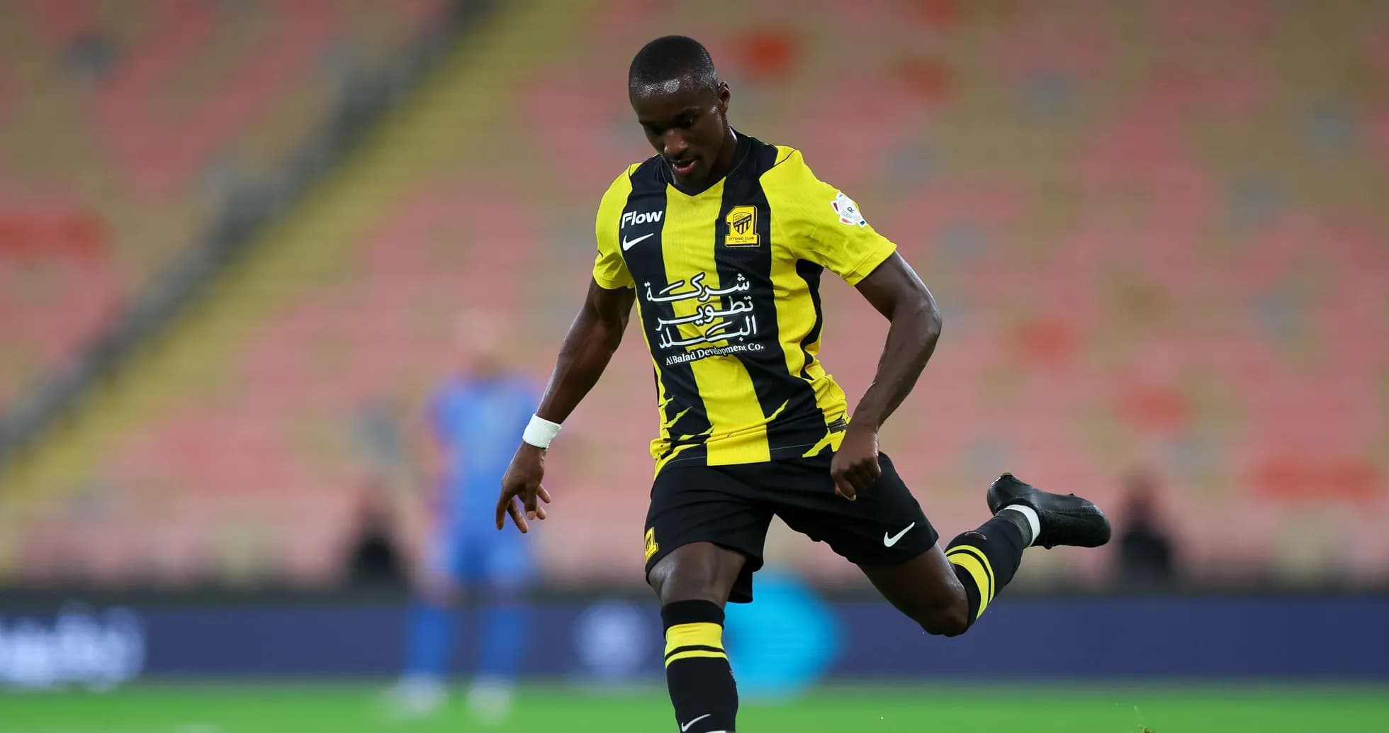 Player in yellow and black kit kicking the ball