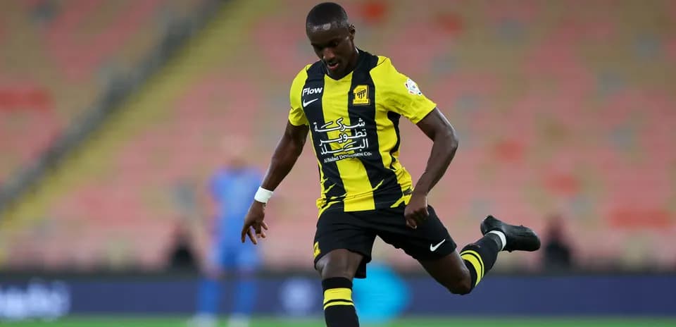 Player in yellow and black kit kicking the ball
