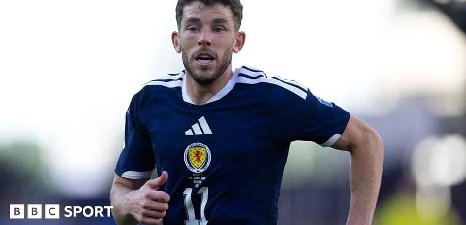 Player running during a football match in Scotland kit