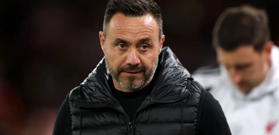 Coach in a puffer jacket during match