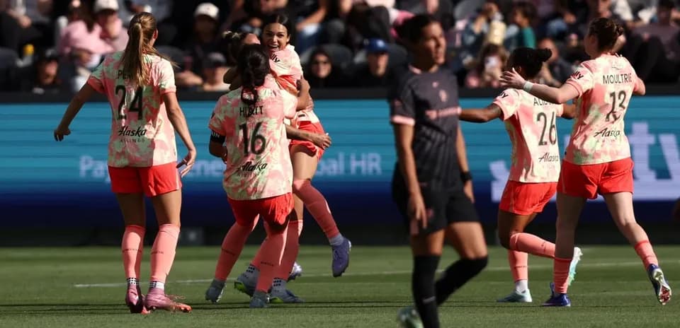 Players celebrating a goal during NWSL match