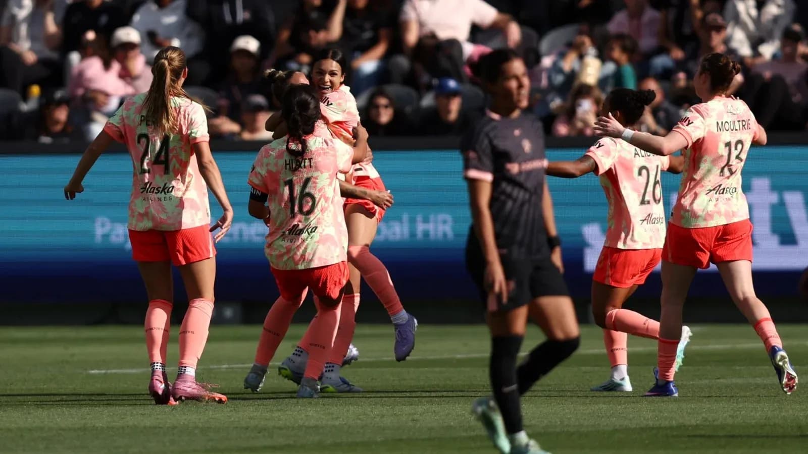 Players celebrating a goal during NWSL match