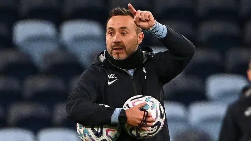 Coach instructing players while holding footballs