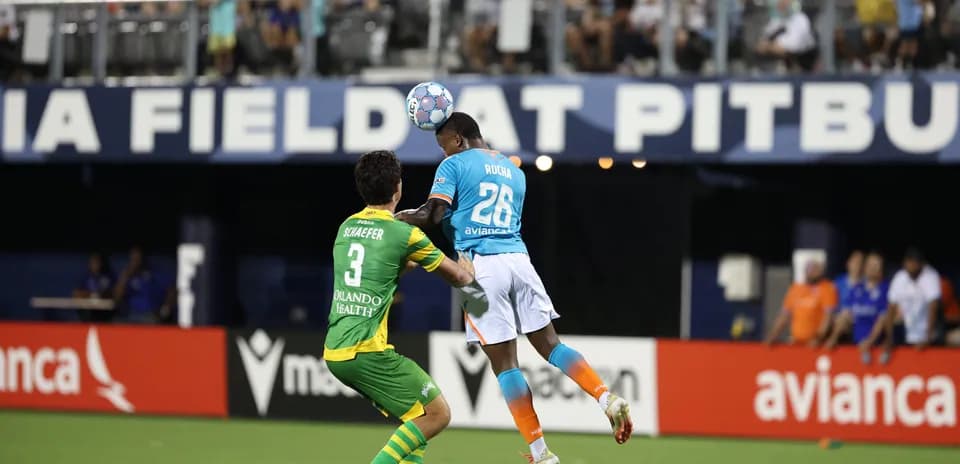 Player heading the ball during Miami FC match