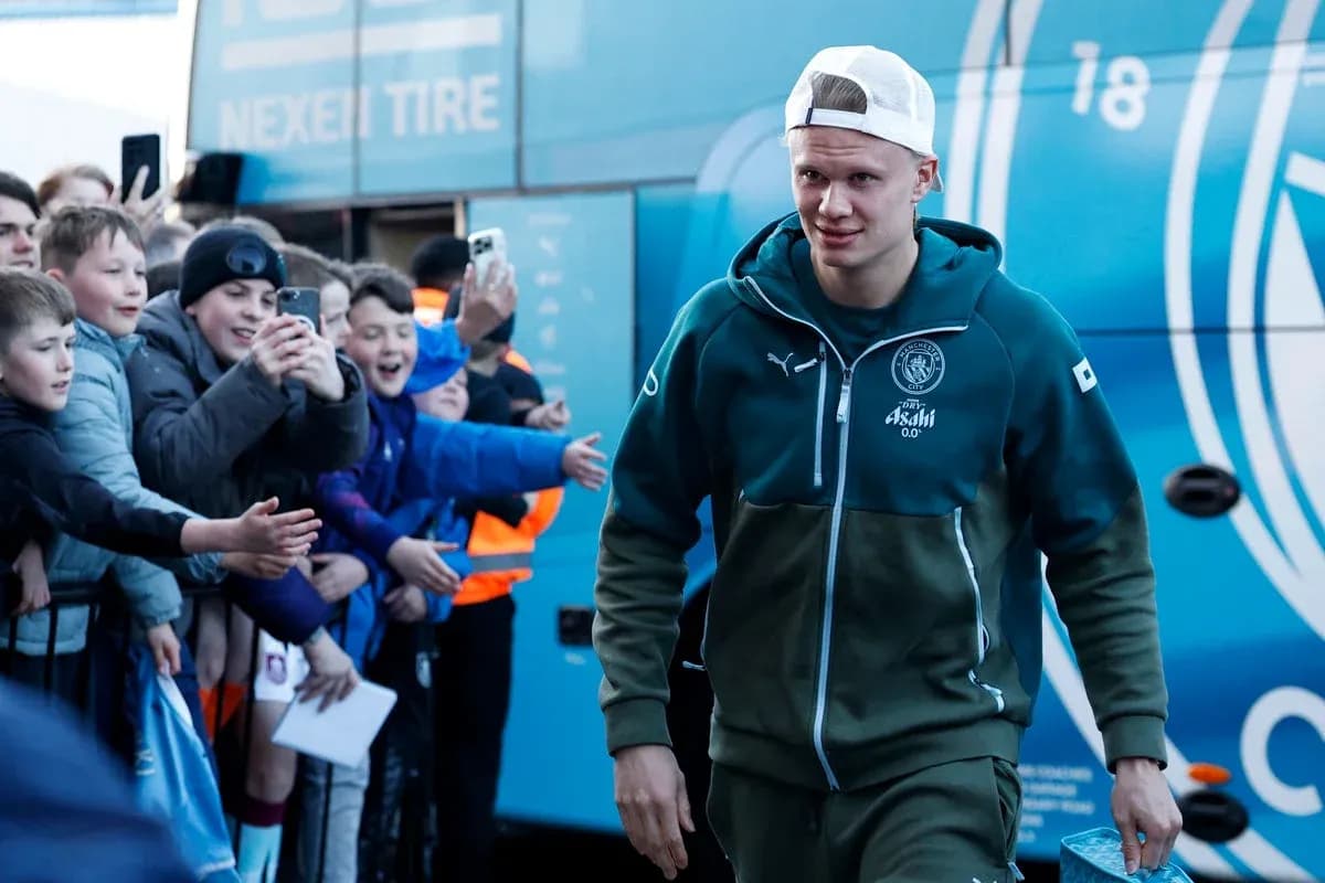 Player arriving at team bus with fans cheering