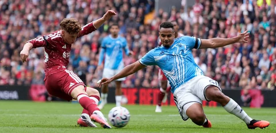 Player in red sliding to tackle opponent in blue