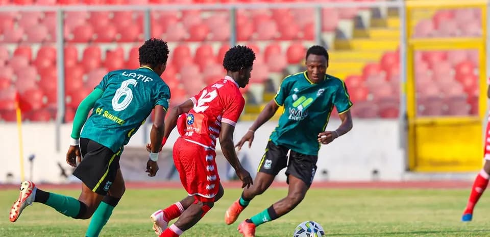 Players competing for the ball during football match