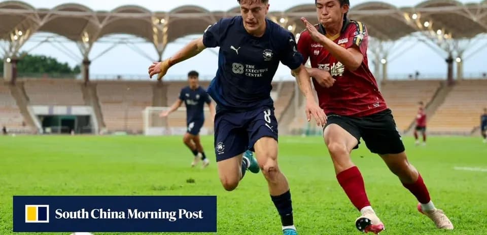 Player in blue jersey dribbling past opponent in red jersey